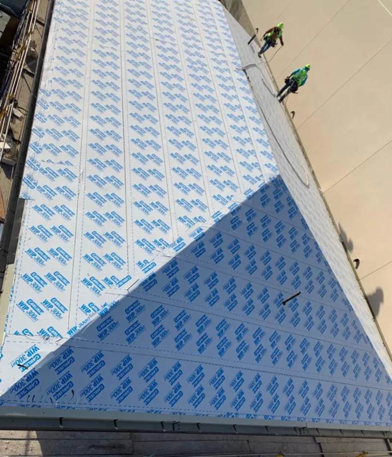 Professional roofers installing underlayment on a metal roof in Newcastle